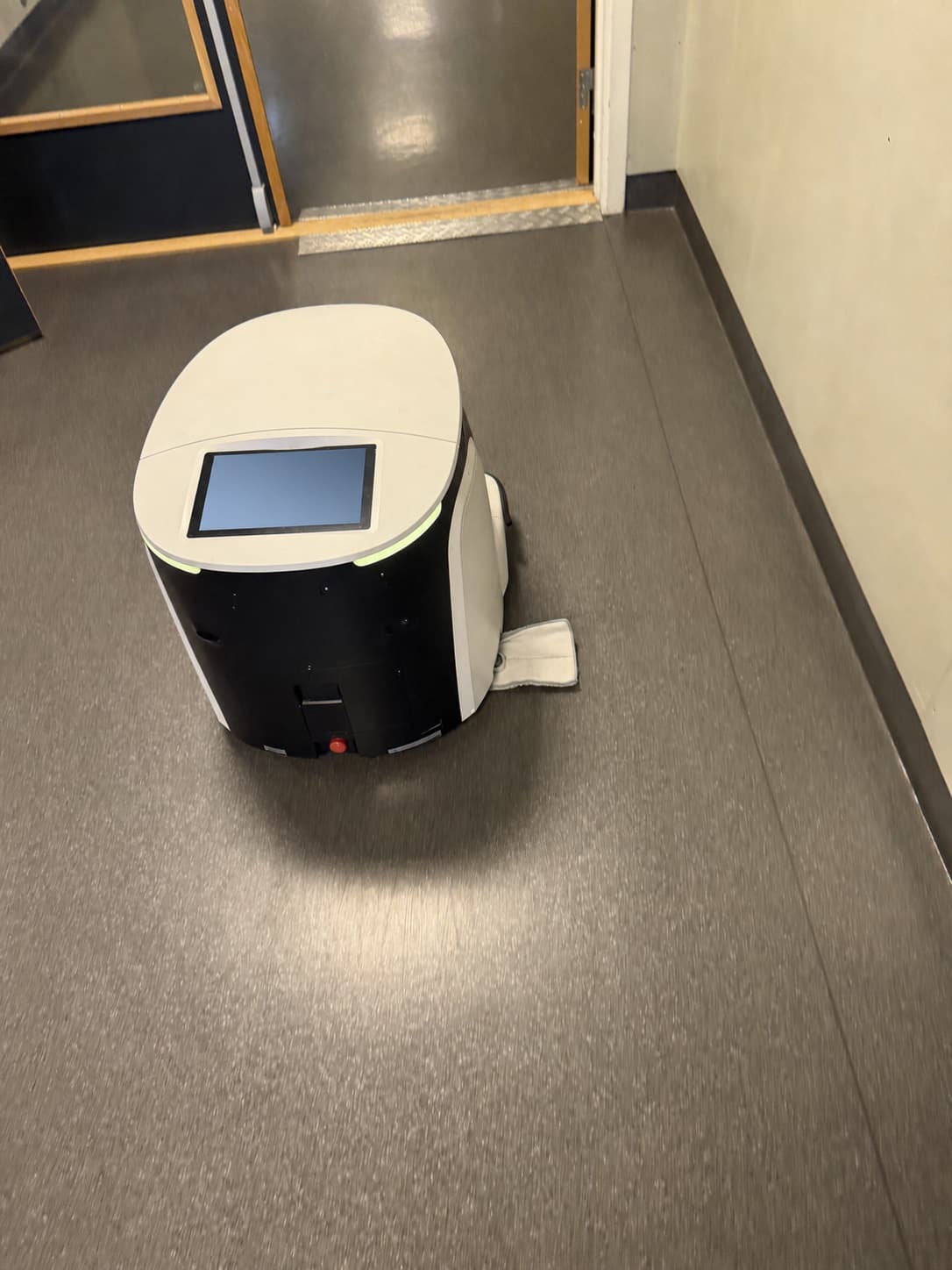 Kompakt autonom rengjøringsløsning på vei gjennom en dørpassasje.